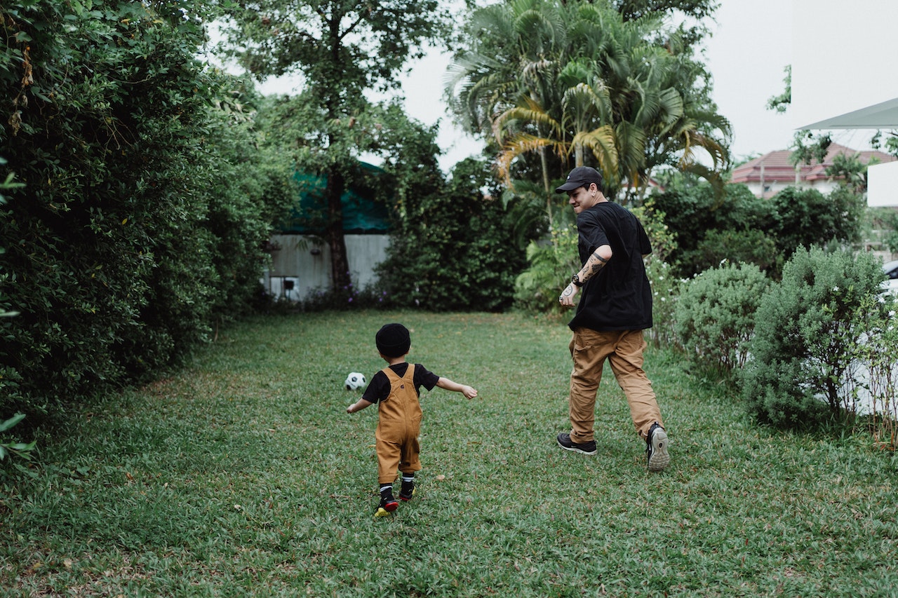 Father and child playing football