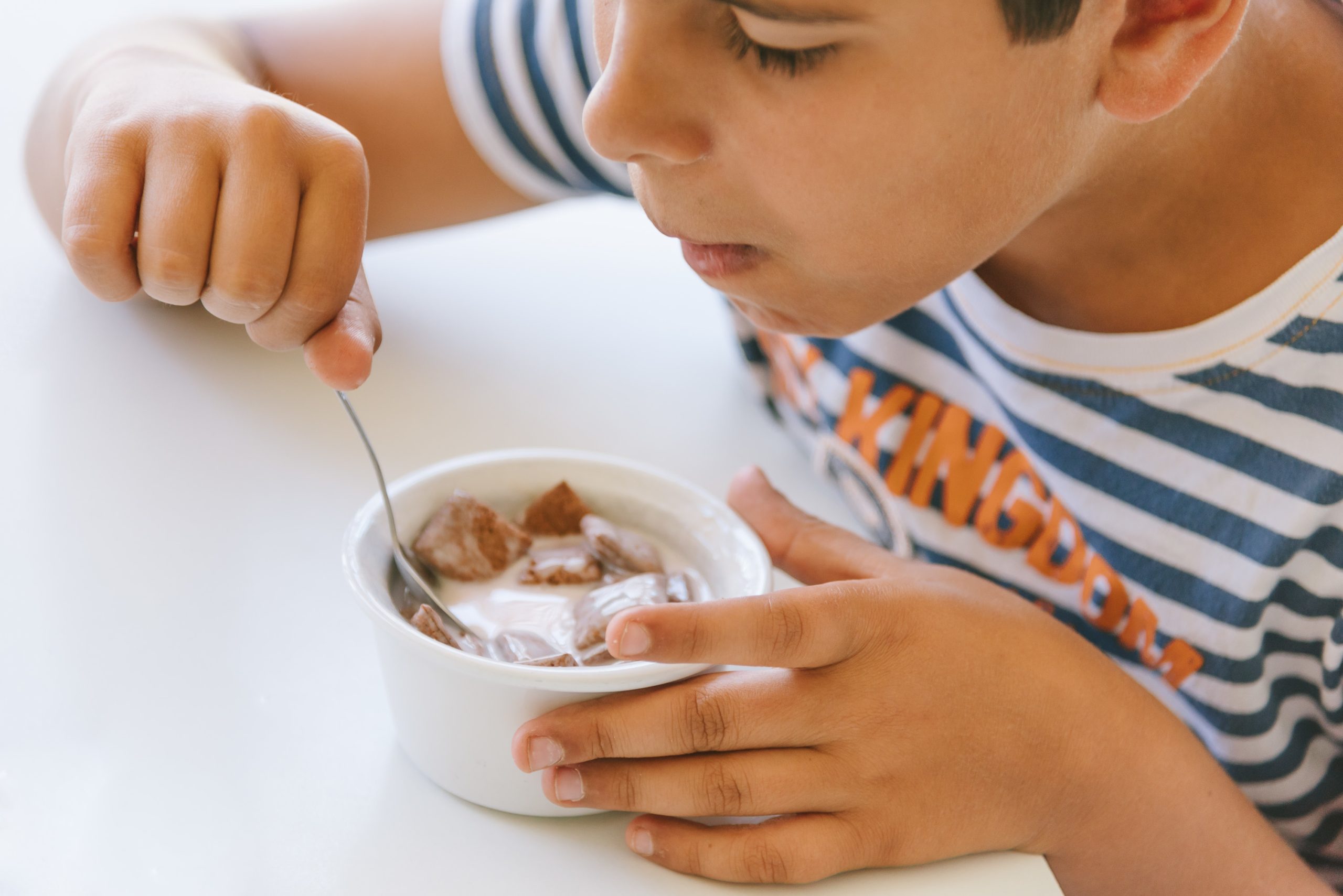 boy eating yoghurt and cereals