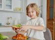 Smiling Boy Eating Sandwich at Home